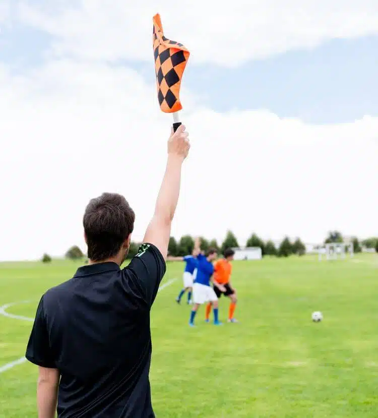 در مقاله ی آفساید چیست این عکس یک داور را در زمین فوتبال نشان می‌دهد که پرچم آفساید را به نشانه ی خطا بالا اورده است.